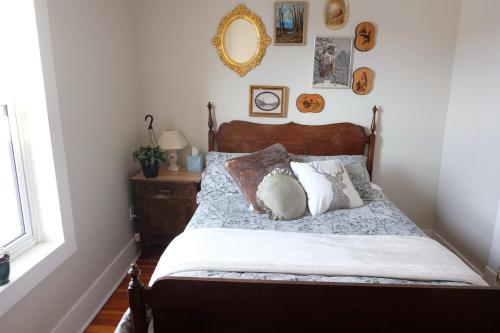 a bedroom with a bed with pillows and a mirror at Entire Home - Downtown river trails & Remai Modern in Saskatoon