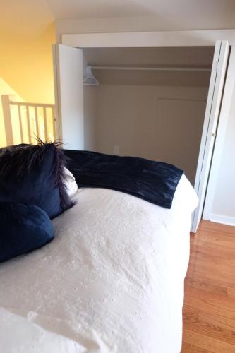 a bed with blue pillows on top of it at Entire Home - Downtown river trails & Remai Modern in Saskatoon
