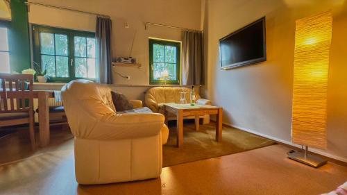 a living room with a chair and a table at Hotel Olbernhau mit Sauna - Kleines Landhotel zur Ofenschenke in Olbernhau