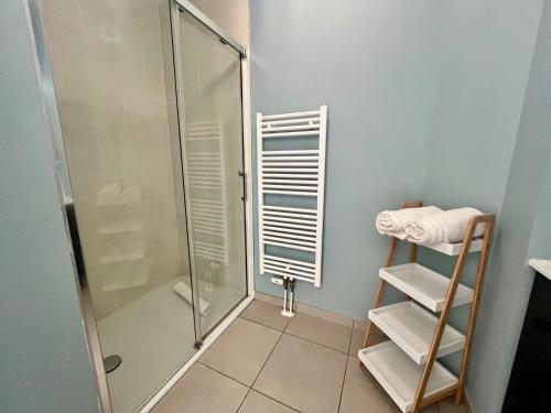 La salle de bains est pourvue d'une cabine de douche et de carrelage. dans l'établissement L'intemporel plage - Malo'Cation, à Dunkerque