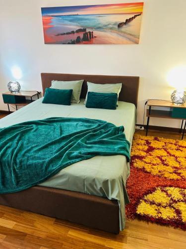 a bedroom with a large bed with a green blanket at Amarelaje in Serra de El-Rei