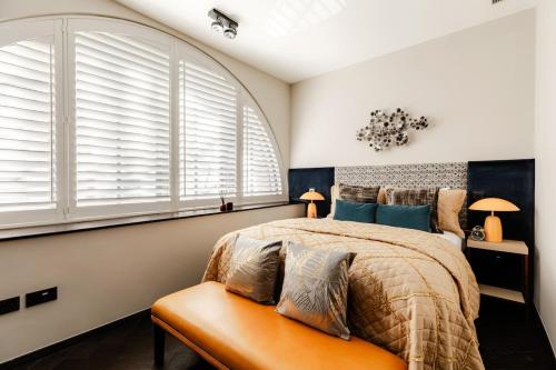 a bedroom with a bed and two windows at JOKER! Off Oxford St! 3Bed 3Bath LuXXe Hideaway for Stylish Families and Couples in London