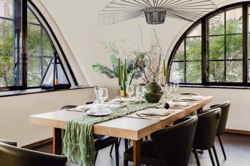 a dining room with a table and chairs and windows at JOKER! Off Oxford St! 3Bed 3Bath LuXXe Hideaway for Stylish Families and Couples in London