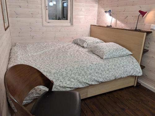 - une chambre avec un lit, une chaise et une lampe dans l'établissement Roulotte avec terrasse à Montreuil, à Montreuil