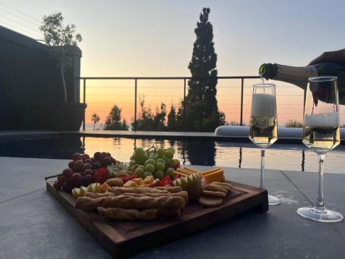 a plate of food and a glass of wine on a table at Cape20 - Luxury Villa Stay in Cape Town