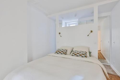 - une chambre blanche avec un lit et 2 oreillers dans l'établissement Charment appartement sacrée Coeur Montmartre, à Paris