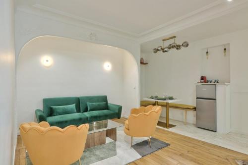 un salon avec un canapé vert et une table dans l'établissement Charment appartement sacrée Coeur Montmartre, à Paris
