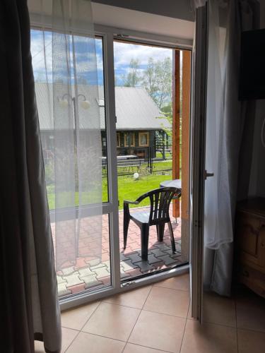 a sliding glass door with a bench on a patio at Pokoje Maria Międzybrodzie Bialskie in Międzybrodzie Bialskie