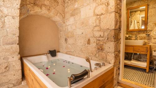 a bathroom with a bath tub in a stone wall at otel alba Alaçatı in Cesme