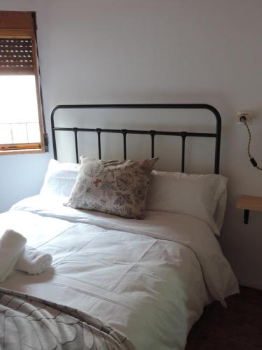 a bed with white sheets and pillows in a bedroom at El Carmen in Cazorla