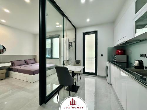 a kitchen and living room with a bed and a table at The LuxHomes Apartment ᵀᴹ I HOT Độc Đáo Nhất Vinhomes Marina in Hai Phong