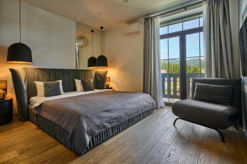 Un dormitorio con una cama y una silla y una ventana. en Golden Chalet, en Bukovel