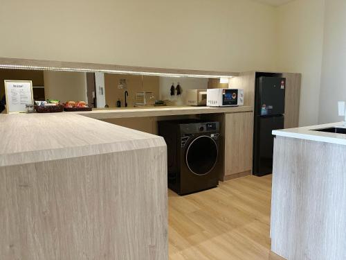 a kitchen with a washer and dryer in a room at SummerDay Seaview Studio Apartment at Kota Kinabalu City Centre in Kota Kinabalu