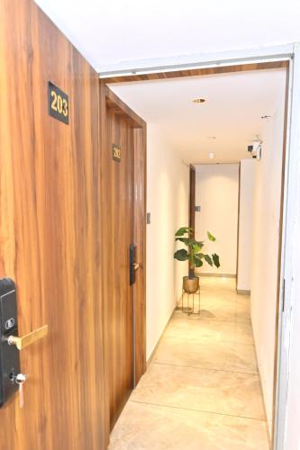 a hallway with a door and a potted plant at Hotel Preston Inn in Mumbai
