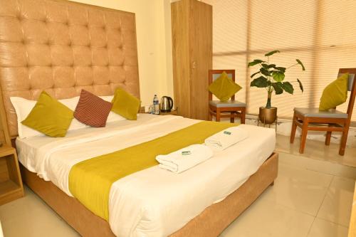 a bedroom with a large bed with two towels on it at Hotel Preston Inn in Mumbai