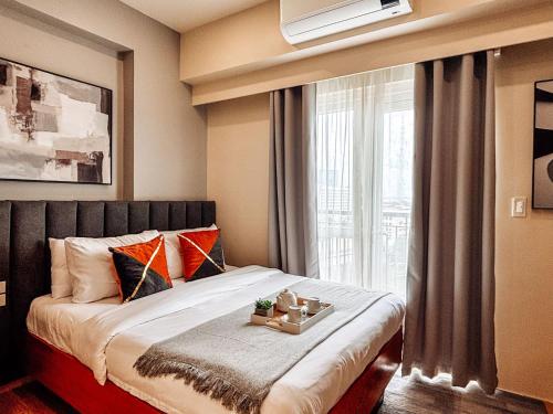 una camera da letto con un letto grande con una finestra di Luxe City Studio Hideaway a Città di Iloilo