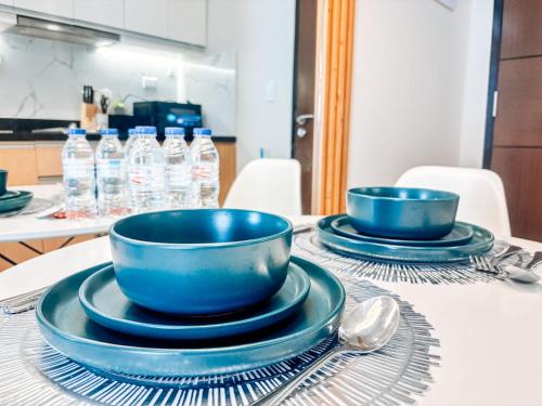 due ciotole e piatti blu su un tavolo con bottiglie d'acqua di Luxe City Studio Hideaway a Città di Iloilo