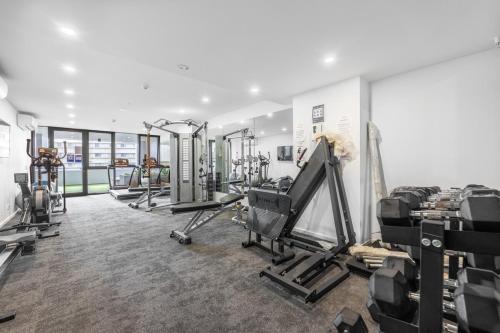 a gym with several treadmills and exercise machines at Modern City 2B&2B Retreat Await in Canberra
