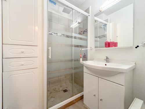 une salle de bain blanche avec un lavabo et une douche dans l'établissement 2 pièces apartement à Fréjus avec parking, à Fréjus