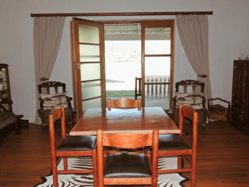 a dining room with a wooden table and chairs at The Wild Olive Sanctuary Accommodation in Paterson