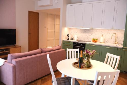 una cucina e un soggiorno con tavolo e divano di Tiffany Residence a Pärnu