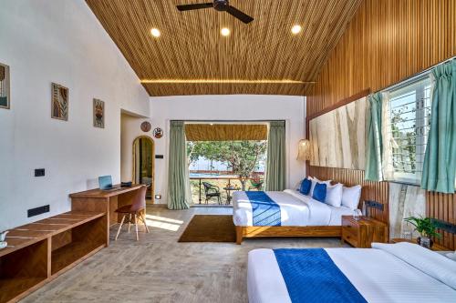 a hotel room with two beds and a desk at SaffronStays Eagle's Span in Malavli