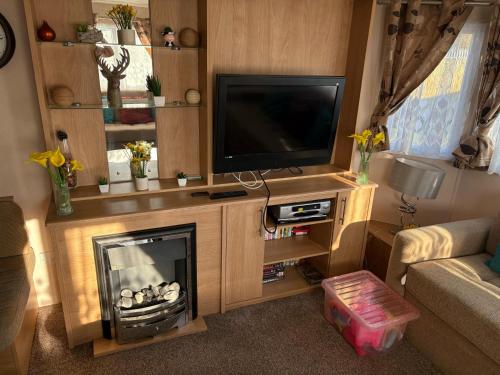 a living room with a tv and a fireplace at Skegness Butlins 8 Berth Caravan in Skegness