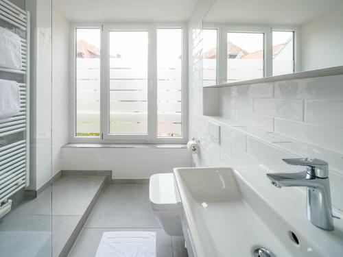 a white bathroom with a sink and a toilet at Hotel Restaurant Goldener Engel in Heppenheim an der Bergstrasse