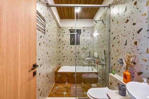 a bathroom with a shower and a toilet and a sink at SaffronStays Eagle's Span in Malavli