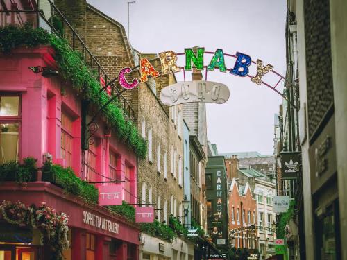 a city street with a sign that reads happy birthday at JOKER! Off Oxford St! 3Bed 3Bath LuXXe Hideaway for Stylish Families and Couples in London