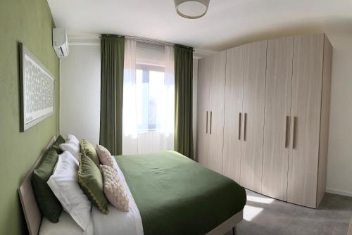 a bedroom with a bed with green sheets and pillows at New apartment-Sotto la Torre in Monsummano