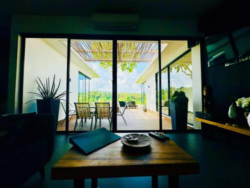 a living room with a table and a view of a patio at Balisen Luxury Villas in Jasri