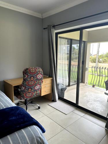a bedroom with a desk and a chair and a sliding glass door at Laid-Back Tortoise in Fisherhaven