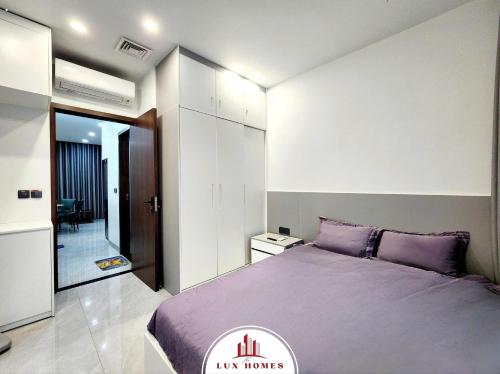 a bedroom with a large purple bed in a room at The LuxHomes Apartment ᵀᴹ I HOT Độc Đáo Nhất Vinhomes Marina in Hai Phong