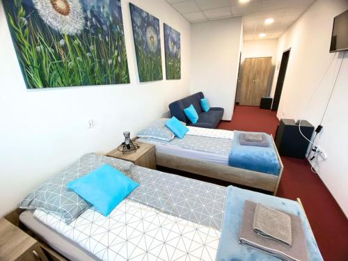 una habitación de hotel con dos camas y un sofá en Noclegi w Wahadle, en Brześć Kujawski