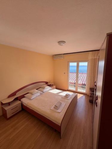 a bedroom with a large bed and a large window at Apartment Tribanj Florida in Viniština