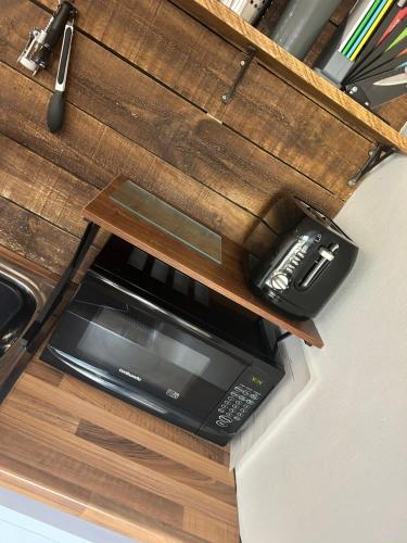 a counter with a microwave and a phone on it at Aiskew Villa Annex in Bedale