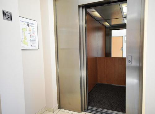 an elevator in a office building with a door at Kyriad Prestige - Bordeaux Aeroport in Mérignac