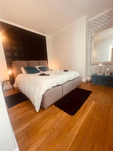 une chambre avec un grand lit blanc et du parquet dans l'établissement La Galerie, suite pour 2 personnes avec chambre supplémentaire possible, à Saint-Fargeau