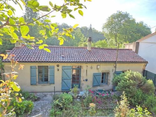 a small house with blue windows and a garden at Le Pont Haut vue sur Rivière proche Puy du Fou in Mortagne-sur-Sèvre