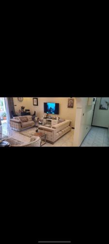 a large living room with couches and a tv at Marble leaf in Nakuru