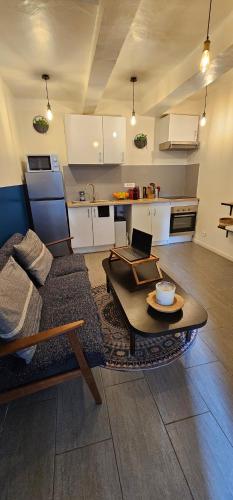 un salon avec un canapé et une table dans l'établissement T2 Chambre Miroir jardin et parking privé Marseille, à Marseille