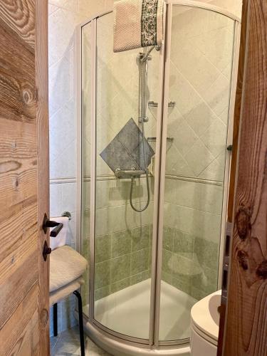 a shower with a glass door in a bathroom at Chalet Valeruz in Canazei