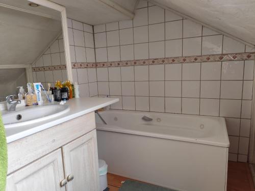 a bathroom with a sink and a bath tub at Petite chambre in Aigueblanche