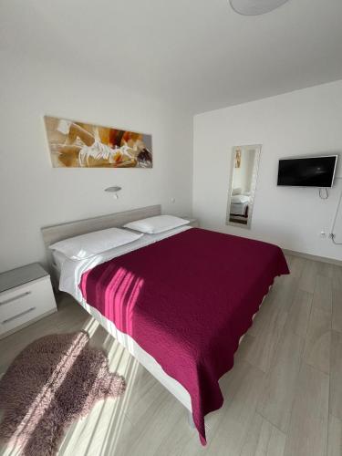 a bedroom with a large bed with a red blanket at Apartman TESSA in Vela Luka