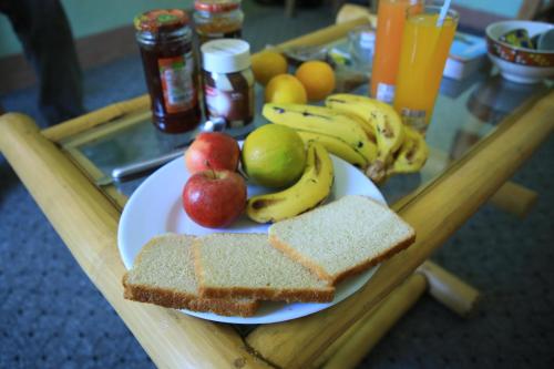 un tavolo in legno con un piatto di frutta e pane di Manuhie Backpackers Lodge a Bahar Dar
