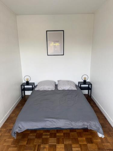 Ce lit se trouve dans un dortoir blanc doté de 2 lampes. dans l'établissement Appartement Châlons en champagne, à Châlons-en-Champagne