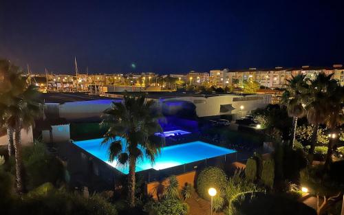 - un grand bâtiment avec une piscine la nuit dans l'établissement Ambassades du soleil 12, au Cap d'Agde