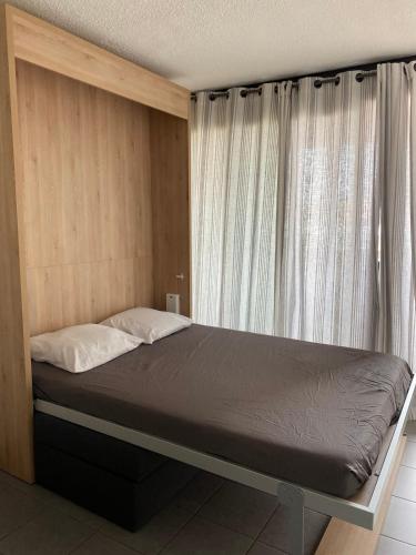 un lit dans une chambre avec une grande fenêtre dans l'établissement Ambassades du soleil 12, au Cap d'Agde