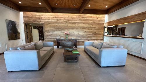 a living room with two couches and a table at Hotel Villa El Descanso Express in Curicó